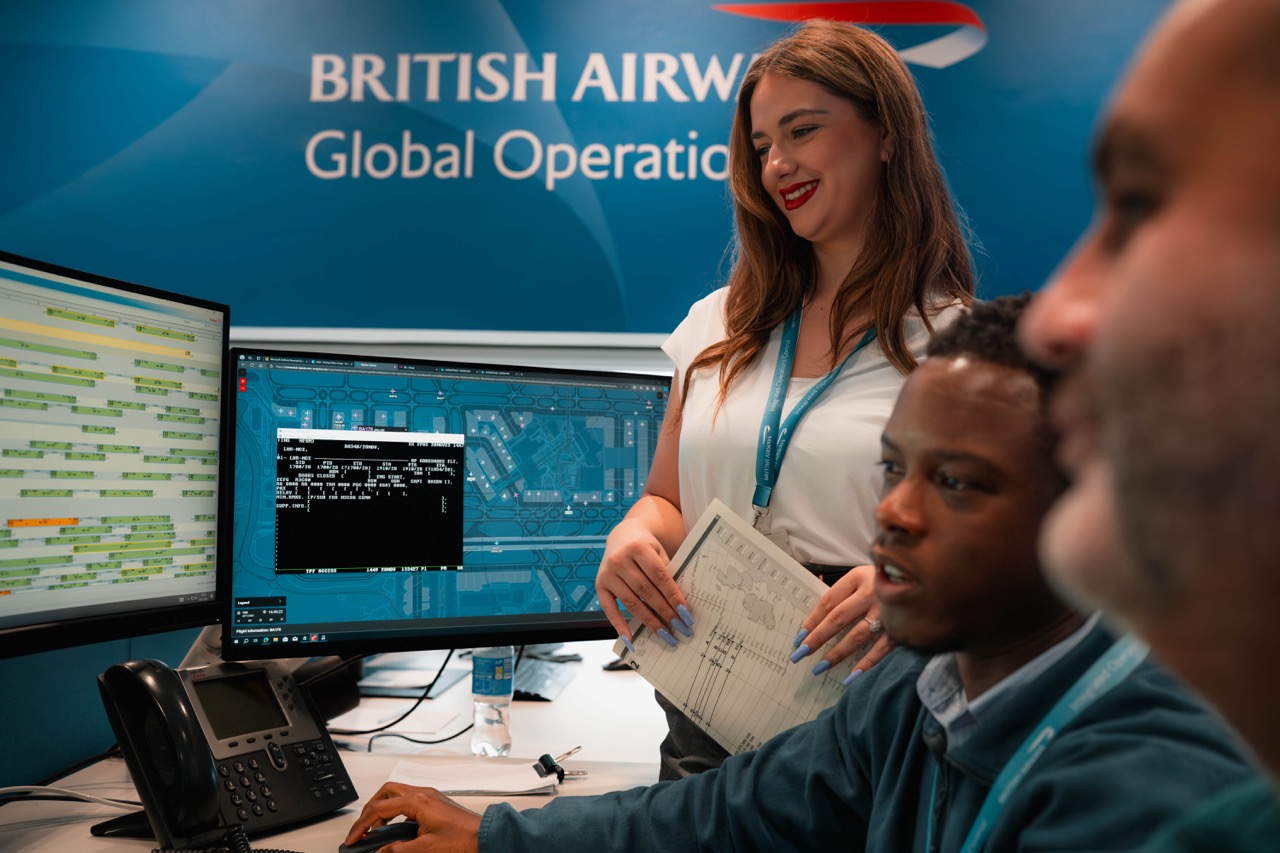 Three colleagues at British Airways looking at a computer screen together.